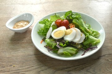 boiled egg with vegetable thousand island salad on plate dressing cream sauce