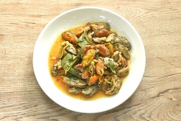spicy stir fried mussel with chilin and basil leaf in curry sauce on plate 