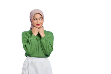 Beautiful smiling Asian woman in green sweater keeps hands under chin, looks aside, remembers pleasant moment isolated on transparent background