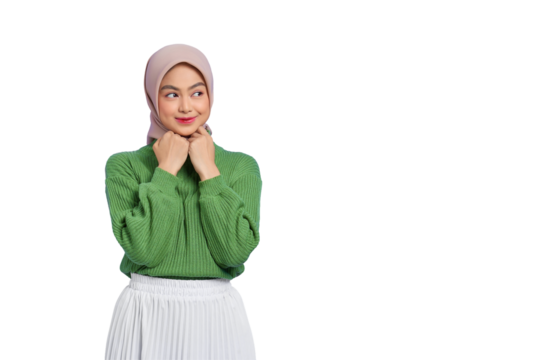 Beautiful smiling Asian woman in green sweater keeps hands under chin, looks aside, remembers pleasant moment isolated on transparent background