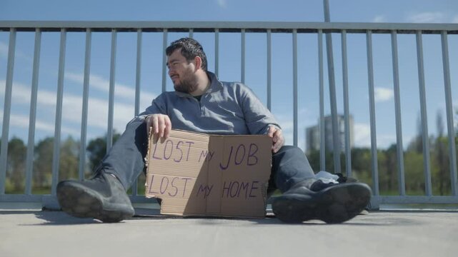 Homeless man expressing struggles by bridge in financial crisis
