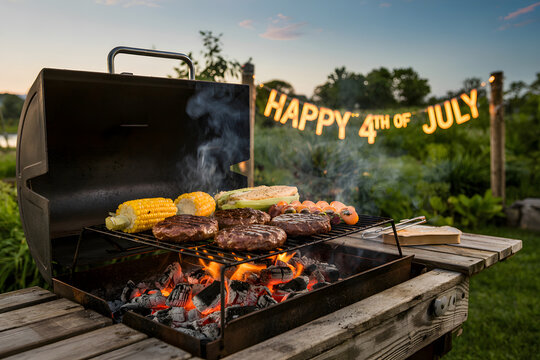 Grilling burgers and corn for 4th of july celebration in garden