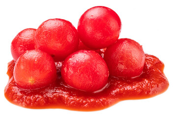 Peeled cherry tomatoes in tomato sauce or ketchup puddle close-up on a white background.