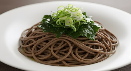 A plate of chilled soba noodles garnished with seaweed and green onions