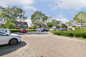A well-maintained parking area in a residential neighborhood, featuring trees and parked cars. The space is inviting and reflects a peaceful suburban atmosphere.