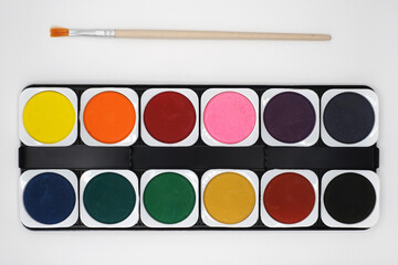 watercolor paint set colors and paintbrush on white background