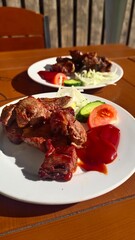 Delicious grilled meat skewers served on a plate with fresh vegetables and herbs.