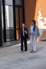 Friends enjoy a leisurely walk in an urban space while engaging in conversation during the afternoon