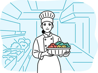 キッチンで食材を持っている女性の料理人