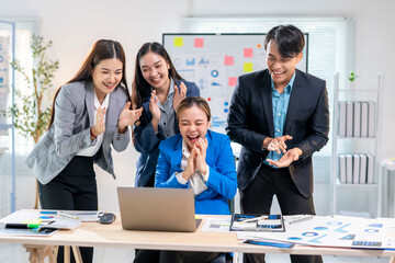 A group of people are celebrating a victory in a business setting