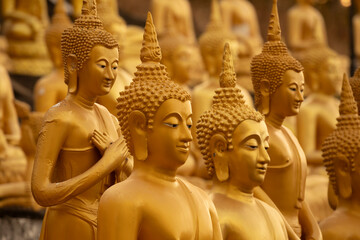 Golden Buddha statues, seated in different meditation positions, at the Wat Phousalao temple, near...