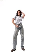 Fashion model poses confidently in casual attire on a white background during a studio photoshoot