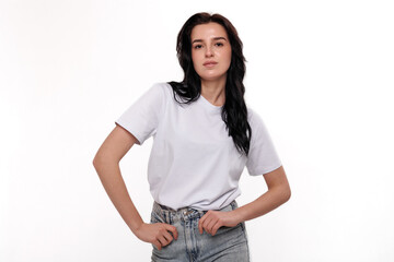 Obraz premium Young woman poses confidently in casual outfit against plain background