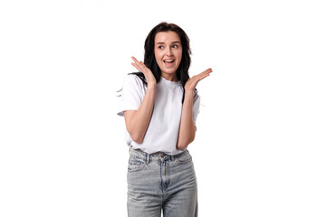 Young woman expresses excitement with a joyful gesture in a bright studio setting during daylight hours