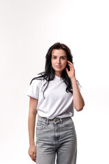 Fototapeta premium Young woman posing thoughtfully in casual attire against a plain background