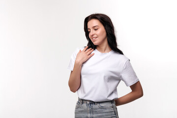 Young woman in casual outfit smiling while posing against a neutral background during a studio...