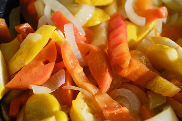 Fresh raw fried vegetables in a frying pan, close up. Shallow depth field