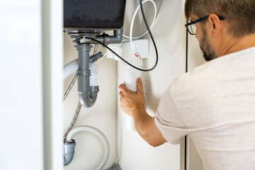 Replacement water purifier. Plumber installs water filter and changes water filter cartridges in...