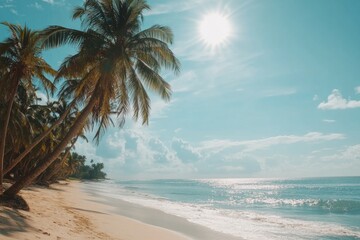 Beautiful tropical beach with palm trees and blue sky with the sun shining on the sea.