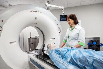 A young woman wearing an immobilization mask undergoes computed tomography before radiation...