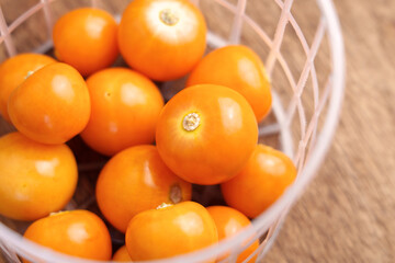 Raw Physalis peruviana fruits in supermarket plastic basket. Ground cherries. Macro. Top view. 