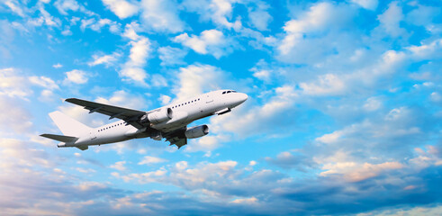 Airplane flying in the sky - travel background with flying airplane with blank livery, summer travel concept