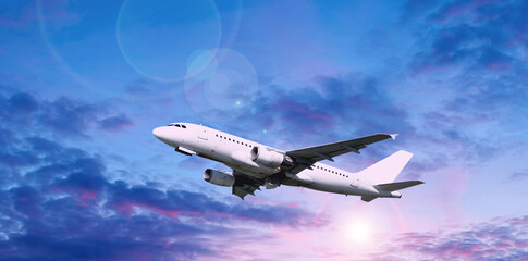 Airplane flying in the sky, white commercial flying airplane in the flight in the sunset sky, red...