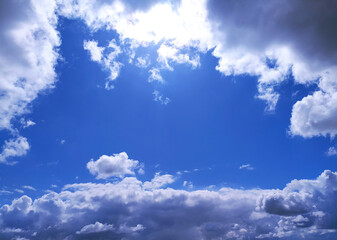 Bright blue sky framed by fluffy white and dark clouds. Inspiring, peaceful, and perfect for adding...