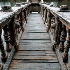 Naklejka premium Weathered wooden bridge leading over calm water, surrounded by lush greenery and serene nature