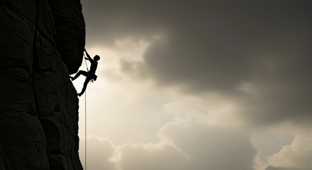Rock Climber Silhouette on Cliff Under Cloudy Sky