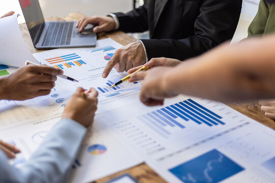 Business people analyzing charts and graphs during a meeting. Business team analyzing financial charts and graphs, discussing strategies.