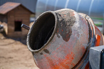 Dirty orange concrete mixer close-up on doghouse background