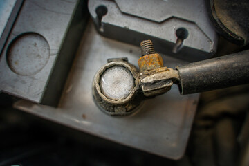 Wire connected to battery terminal in car close-up