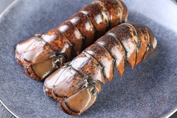 Two raw lobster tails on plate, closeup