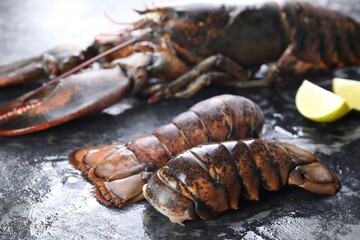 Raw lobster, tails and lime on dark table, closeup