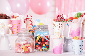 Candy bar. Many different sweets on table in festive decorated room