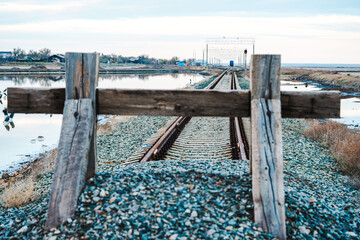 End of the road. The railway tracks are covered with gravel and covered with a wooden fence. Dead...