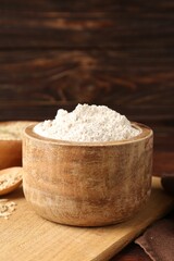 Brown rice flour on wooden table, closeup. Space for text