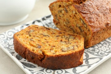 Cut homemade carrot cake with nuts on table, closeup