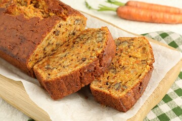 Homemade carrot cake with nuts and vegetables on table, closeup