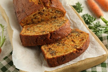 Homemade carrot cake with nuts and vegetables on table, closeup