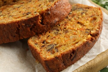 Cut homemade carrot cake with nuts on table, closeup