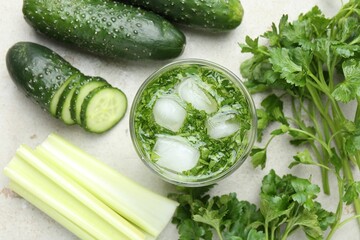 Healthy drink with parsley, cucumbers and celery on light table, flat lay