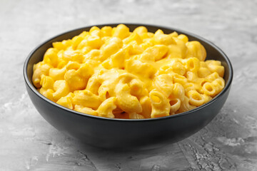 Delicious pasta with cheese sauce in bowl on grey table, closeup