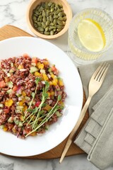 Tasty salad with brown rice served on white marble table, flat lay