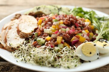 Tasty salad with brown rice on wooden table, closeup