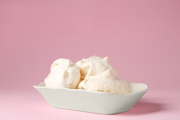 Delicious homemade meringue cookies in bowl on pink background