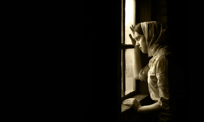 Orthodox devote adult lone worry fail poor holy lady trust ask plead god Jesus Christ peace love old Ukraine history. Cold war young human teen face think life dark home room text space look light sky