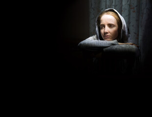 Lone sad pretty girl in dark room