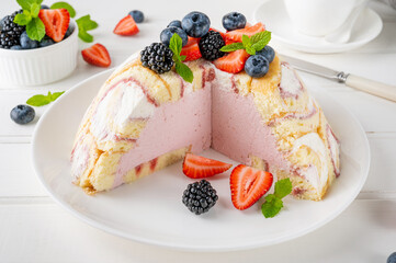 Charlotte Royale Cake with strawberry cream inside and decorated fresh berries. Delicious summer cake.